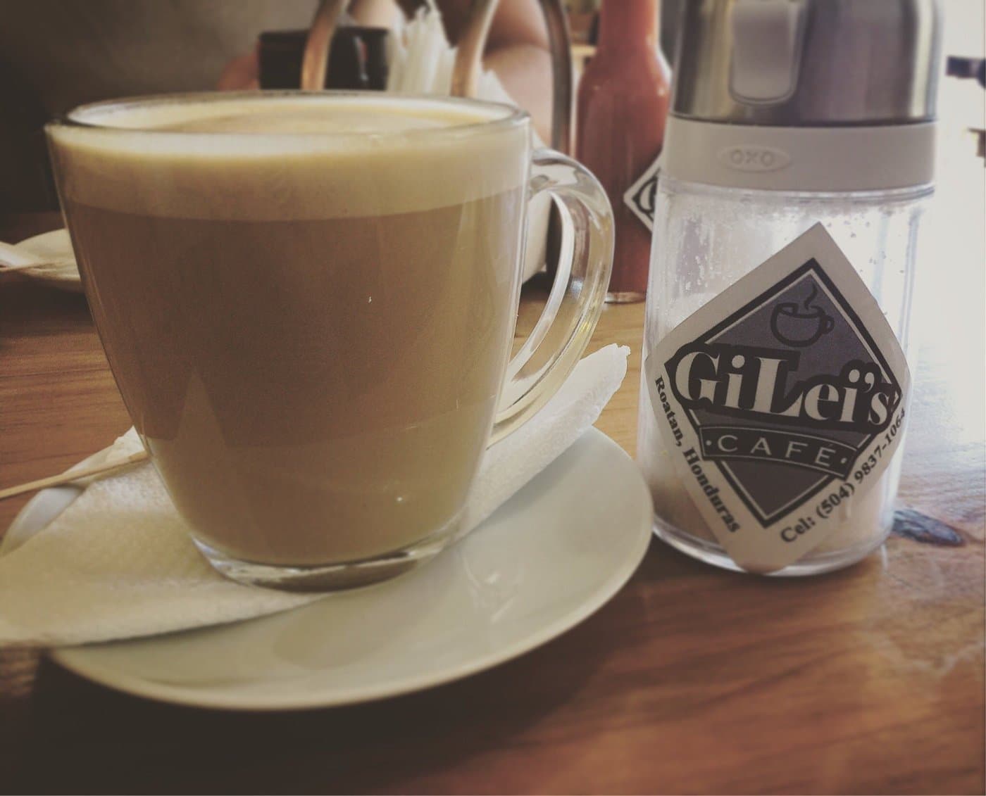 A latte at GiLei's Café, served with a GiLei's branded sugar packet